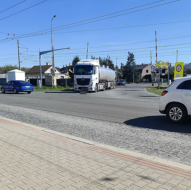 Vlak ho těsně minul. Kamion na přejezdu uvázl za závorou, svědek incident vyfotil